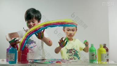 小男孩和小女孩用涂满颜料的手<strong>画画</strong>